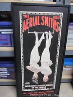 Framed vertical poster showing trapeze artists and text 'The Great Aerial Smiths'