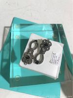 Pair of Judith Jack sterling silver drop earrings on white foam in aqua glass box, top-side view showing intricate marcasite patterns and stones