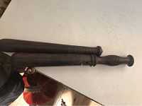 Two antique wooden billy clubs placed on a white surface, showing overall length and finish.