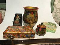 Lot composed of several hand painted decorative boxes and a vase from India and Russia, arranged for clear viewing.