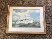 Overall view of framed watercolor painting on patterned fabric background