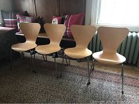 Four chairs lined up side by side on rug.