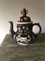 Front view showing the teapot with the inscription 'Home Sweet Home' and bird decorations.