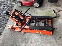 Top-angle view of the Harley Davidson motorcycle lift showing the foot pedal and securing straps.