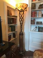 Full view of lamp in room setting showing overall height, twisted column and shade.