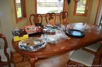 Photo showing various holiday cookie cutters, mini muffin trays, and silver-colored oval serving trays on a wooden table.