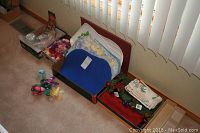 Wide view showing five sets of placemats in blue, red, and other colors, cloth napkins, decorative napkin rings in fruit designs, new candle making kit and craft moss and rocks