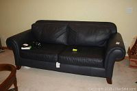 Full front view of the Broyhill leather sofa showing two seat cushions and two large back cushions in dark leather.
