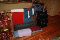Photo of the folded quilt, pillows, pillowcases, and the Tommy Hilfiger seating cube, showing overall lot contents.