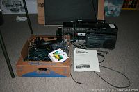 Full lot view showing Sony CFS-W600 boombox, box of cables and Chromecast device with manual on carpeted floor.