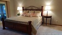 Full view of assembled California King bed with headboard, footboard, bedding and side tables