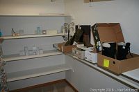 Photo of women's footwear arranged on shelving including boots in boxes and new home scents