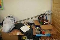 Box containing various sports equipment including nets, goggles, and miscellaneous items seen from a distance on stacked boxes.