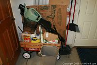 Photo shows Radio Flyer wagon loaded with various gardening supplies including watering can, hanging baskets, and boxes.