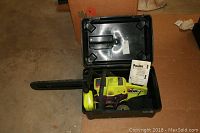 Poulan Wild Thing chainsaw stored inside a black hard plastic carrying case with lid open, showing the chainsaw fully assembled with bar and chain covered.