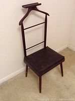 Full view of the silent butler chair showing the wood frame, integrated hanger backrest, and padded seat.