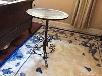 Full view of round side table with slate top and ornate metal base