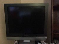 Front view of Samsung TV showing screen and base stand.