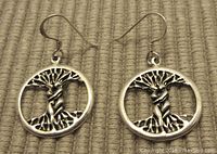 Front view of sterling silver Tree of Life earrings with detailed tree and branches inside circular frame.