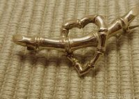 Close-up of front of pin showing heart shape formed by bamboo segments in polished 9 carat gold.