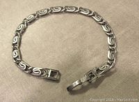 Full view of vintage sterling silver fancy link bracelet laid out to show entire length and clasp detail.