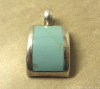 Front view of rectangular sterling silver pendant with light blue turquoise stone and slight natural vein.