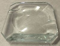 Top view of the heavy clear glass ashtray showing beveled edges and engraving on the bottom.