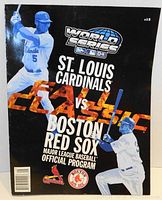 Front cover of the 2004 MLB World Series official program between St. Louis Cardinals and Boston Red Sox featuring players from both teams and Fall Classic text.