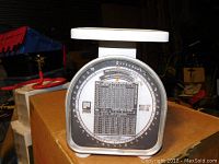 Front view of the Pelouze white tabletop scale showing the detailed measurement dial including food weight and conversion tables.