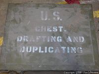 Closed view of the green military chest with white stenciled text on lid.