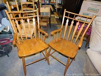 Pair of matching oak chairs showing overall design, armrests, and contoured seats in natural oak finish