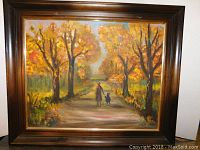 Full view of the framed oil painting showing the autumn scene and figures walking on the path.