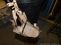 Side view of the rusted metal sailboat sculpture showing hull and sails detail.