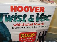 Close-up of the product box showing Hoover Twist & Vac branding, highlighting powered brush roll, E-Z Empty dirt cup, and swivel nozzle.