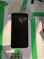 Front of iPhone 6 Plus with screen off and coiled white earphones