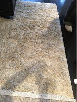 Top view of the cream-coloured thick pile IKEA Gåser area rug, showing fringed edge and pile texture.