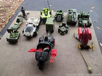 Top-down view of assorted GI Joe military-themed toy vehicles; mostly tanks and helicopters with weapons and turrets.