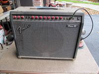Front view of Fender Deluxe 85 amplifier on a table showing control panel, knobs, speaker grille and logo.
