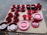 Table set with majority of ruby glassware including cups with saucers, berry dishes, plates and tumblers in deep ruby red.