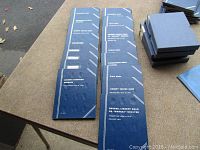 Sixteen blue hardcover coin collecting books laid out on a table in two rows, with printed white text indicating specific coin collections.