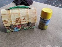 Chuck Wagon lunch box with painted sides and green handle alongside yellow-lidded thermos