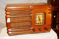 Front view of wooden cabinet radio showing speaker grille and tuning dial