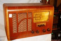 Front view of walnut cabinet, speaker grille, tuning dial and control knobs