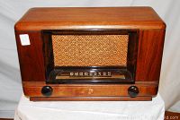 Front view of the vintage wooden Wards Airline radio with woven speaker cloth and AM dial