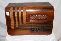 Front view showing wooden cabinet finish, wicker speaker grilles and tuning knobs