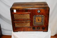 Front view showing wood cabinet, speaker grille, dial and control knobs