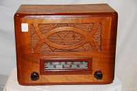 Front view of the wooden Astra vintage radio, showing the decorative wood grille and tuning dial with two black knobs.