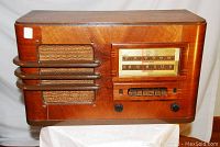 Front angled view showing wood cabinet, speaker grille and tuning dial