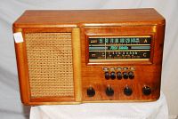 Front view of a vintage wooden cabinet RCA Victor radio with speaker grille and control knobs.