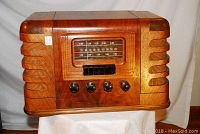 Front view of the restored wood cabinet radio showing dial, pushbuttons, and control knobs.